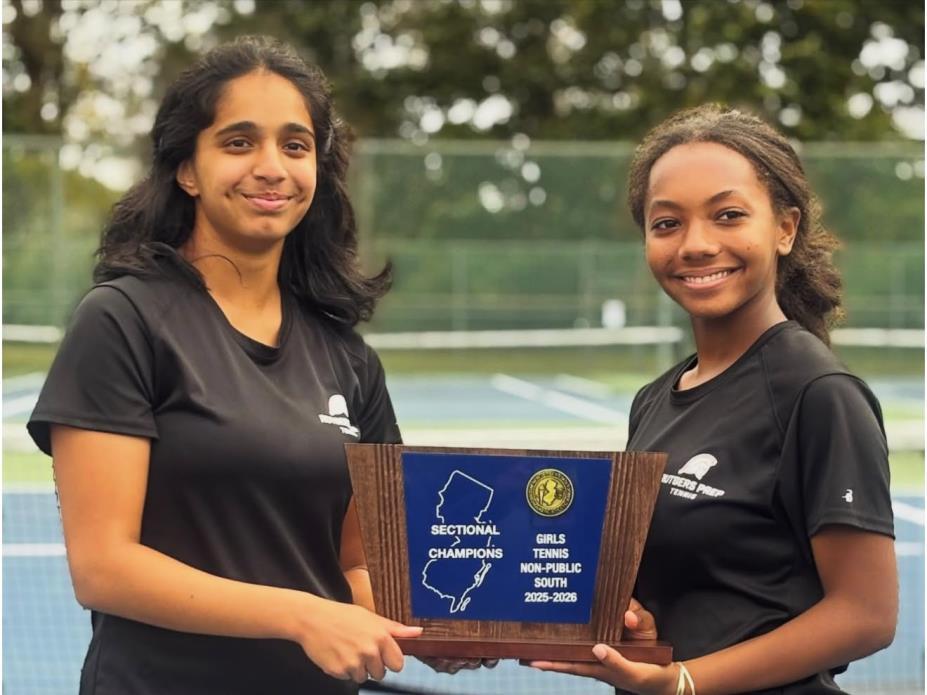Two tennis teammates holding the sectional championship plaque