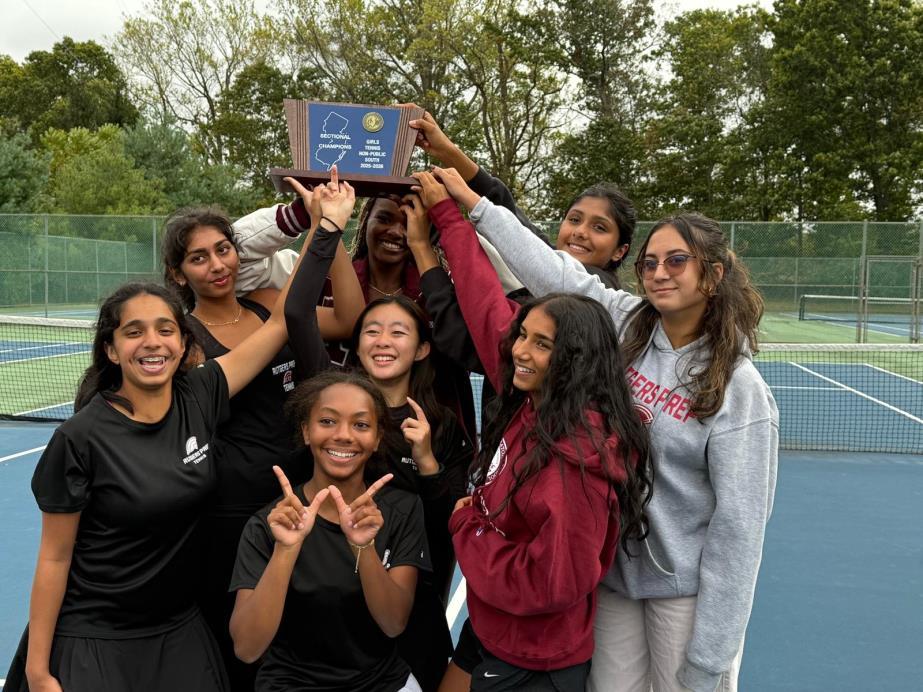 Tennis teammates celebrating with a championship plaque